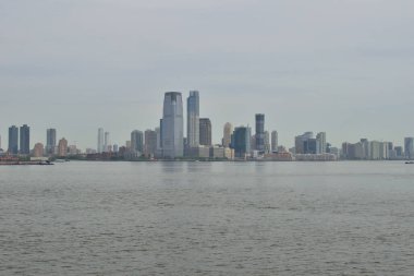 Kentsel genişlemenin bir sembolü olan New York limanından bakıldığında Jersey City 'nin büyüyen ufuk çizgisi belirgin bir şekilde duruyor.