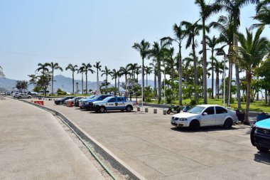 Acapulco, Mexico - April 27 2024: A parking lot with several cars and a truck. The cars are parked in rows and the truck is parked in the middle of the lot. clipart