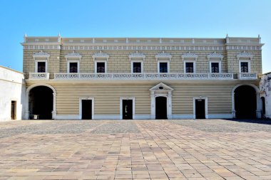 La antigua, Meksika - 7 Aralık 2022: San Juan de Ulua Kalesi 'nde beyaz cepheli ve arkasında mavi gökyüzü olan büyük bir bina. Binanın bir sürü penceresi ve geniş bir kemer yolu var.