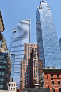 New York, ABD - 17 Mayıs 2023: Highline 'ın ortasında yüksek bir binası olan bir şehir silueti. Gökyüzü açık ve mavi.