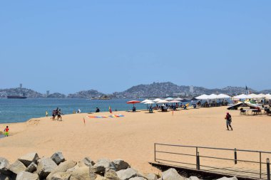 Acapulco, Meksika - 27 Nisan 2024: Acapulco 'da El Morro plajı turistler ve bazı şemsiyelerle