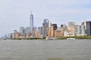 Arka planda New York şehrinin silueti olan bir gökyüzü. Su sakin ve gökyüzü berrak.