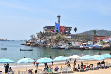 Acapulco, Meksika - 5 Mayıs 2024: Körfez sahilinde terk edilmiş sihirli deniz dünyası ve şemsiyeler