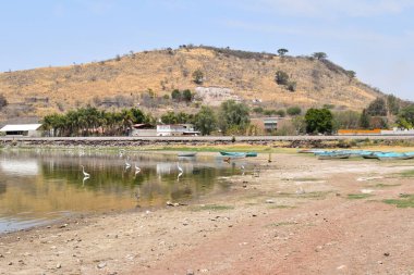 Valencia Barajı 'nda su birikintisi üzerinde birkaç kuş ve birkaç ev, Jalisco.