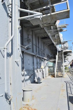 New York, ABD - 17 Mayıs 2023: Gri bir dış görünüşü ve üst güverteye çıkan bir merdiveni olan büyük bir geminin dikey görüntüsü. New York 'taki korkusuz hava ve uzay müzesi