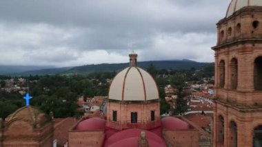 Geriye doğru uçan hava görüntüleri, Jalisco 'nun Tapalpa kentindeki kilise ve merkez plazayı gözler önüne seriyor.