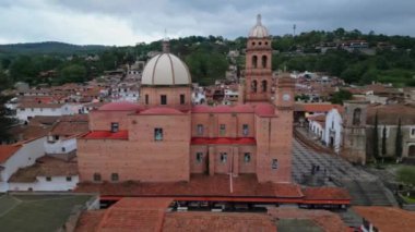 Meksika 'nın Jalisco kentindeki Tapalpa kentindeki kilisenin ve merkez plazanın üzerinde pürüzsüz bir yan insansız hava aracı uçuşu.