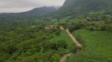 Meksika, Guerrero 'daki yemyeşil yemyeşil ile çevrili La Haciendita restoranına giden kırsal bir yol boyunca uçan bir hava görüntüsü.