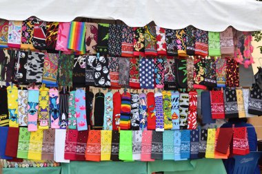 Zapopan, Meksika - 8 Haziran 2024: Renkli bandanalar ve çoraplarla dolu bir masa. Bazı bandanaların kafatası var.