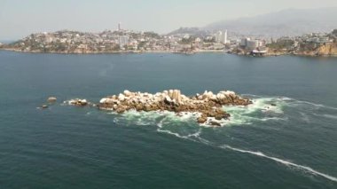 Acapulco 'daki Caleta Sahili yakınlarındaki sakin okyanus sularında ilerleyen bir insansız hava aracı videosu, sakin sahil şeridini ve doğal güzelliği yakalıyor.