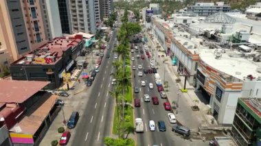 Acapulco 'daki Costera Bulvarı' nda yükselen bir drone videosu canlı şehir manzarasını, hareketli caddeleri ve çevresindeki tropikal manzarayı yakalıyor.