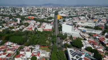 Guadalajara, Meksika - 27 Ekim: Guadalajara 'daki Mariano Otero Bulvarı boyunca uçan bir insansız hava aracı videosu, şehir manzarası ve yeşilliklerle çevrili ikonik Arcos del Milenio' yu gösteriyor.