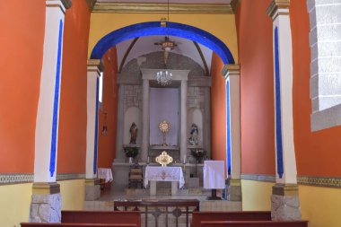 Cuexcomatitlan 'ın kilisesinin parlak ve renkli iç mimarisi sunağı dini detaylar ve canlı tasarımlarla sunuyor.