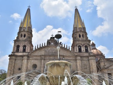 Guadalajara, Meksika - 7 Temmuz 2024: Tarihi merkezindeki ikonik altın kuleleri ve ön fıskiyesi ile Guadalajara Katedrali 'nin yakın görüntüsü
