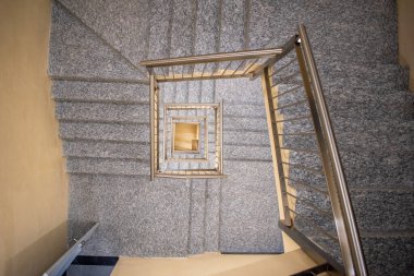 Meksika 'daki Zapopan Sanat Müzesi' nin içindeki metal korkuluklu sarmal merdivenin üst görüntüsü geometrik simetriyi gösteriyor.