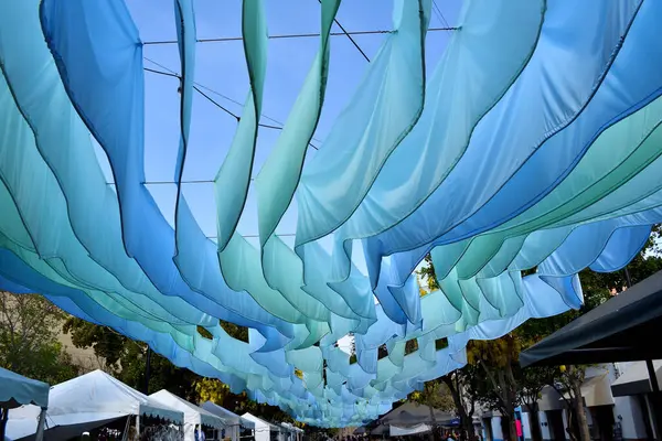 Zapopan, Meksika - 8 Haziran 2024: Zapopan, Jalisco 'daki 20 de Noviembre kaldırımının üzerinde asılı duran mavi kumaş süslemeleri canlı bir şehir atmosferi yaratıyor