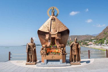 Chapala, Meksika - Noviembre 24 2024: Zapopan Bakiresi heykeli ve Chapala Gölü kenarında açık mavi gökyüzü altında iki bronz muhafız