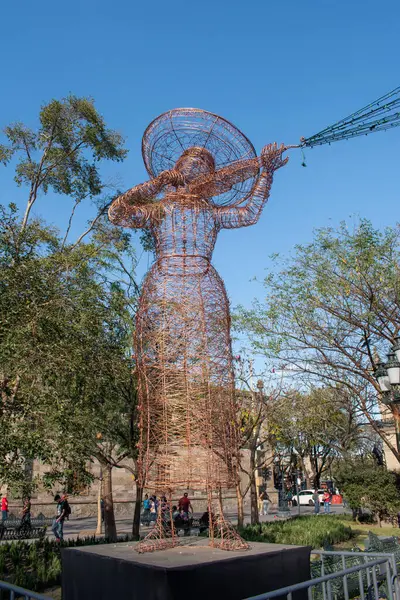Guadalajara, Meksika - 2 Şubat 2025: Guadalajara şehir merkezindeki umumi bir alanda keman çalan Mariachi 'li bir kadını temsil eden sanatsal tel heykel