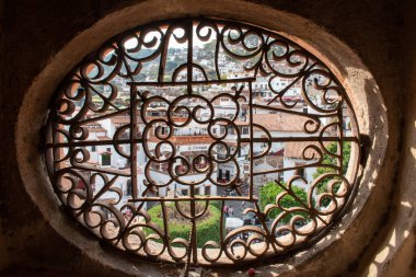 Taxco, Guerrero, Meksika. Tarihi Santa Prisca Kilisesi 'nin içinde güzel süslü dairesel bir pencereden görülüyor.