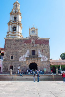 Ajijiç, Meksika - 26 Ocak 2025: Ajijiç, Jalisco 'daki San Andres Apostol tarihi taş kilisesi ve güneşli gökyüzünün altındaki ana meydanda insanlar