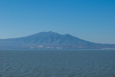 Cerro Viejo 'nun güneşli ve açık bir günde Ajijic, Jalisco, Meksika' dan, Chapala Gölü 'nün ötesinden yükselişinin görkemli manzarası.