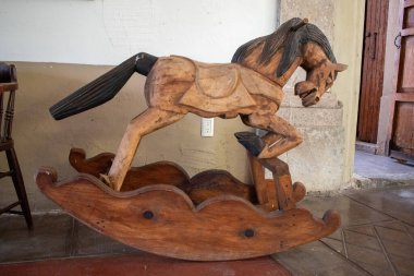 Cocula, Meksika - 27 Nisan 2025: Meksika çiftliğinde sergilenen doğal bitiş ve kıvrımlı tabanlı sanatsal ahşap at