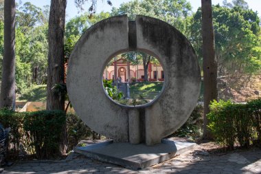 Guadalajara, Meksika - 9 Mart 2025: Colomos Ormanı 'nın ağaçlık bölgesinde ana bina dairesel açıklıktan görülebilen sanatsal beton yapı