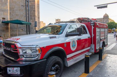 Guadalajara, Meksika - 13 Nisan 2025: Güneşli bir günde Meksika 'nın Guadalajara Jalisco şehrinin tarihi merkezinde, sömürge binalarının yakınlarına park edilmiş kırmızı ve beyaz kurtarma kamyonu