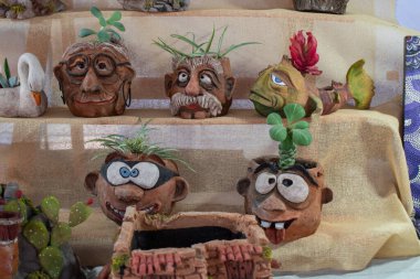 Tlaquepaque, Meksika - 19 Nisan 2025: Çizgi film karakteri şeklinde el yapımı kil ekiciler ve yerel bir zanaatkar pazarında hayvan kafaları