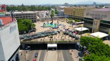 Bir İHA caddelerde ilerliyor ve Quetzalcoatl Çeşmesi üzerinde uçuyor Plaza Tapatia, Guadalajara, Meksika