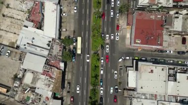 A horizontal drone view featuring a vertical pan along Acapulco's Costera Avenue, showcasing its bustling traffic and urban charm