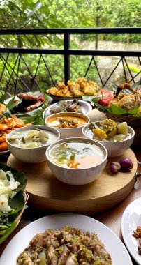 Endonezya çorba tabaklarının çeşitli çeşitleri masada lezzetli yiyeceklerle çevrili.