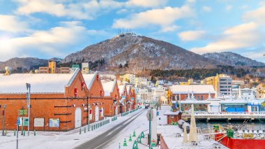Cityscape of the historic red brick warehouses and Mount Hakodate  at twilight in Hakodate, Hokkaido Japan in winter clipart