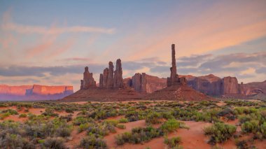 Günbatımında Arizona 'daki Monument Vadisi' nde totem direği ve kum tepeleri.