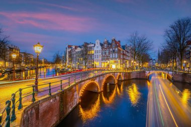 Amsterdam şehir merkezi silüeti. Gün batımında Hollanda 'da şehir manzarası