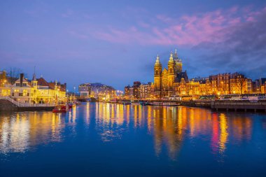 Amsterdam şehir merkezi silüeti. Gün batımında Hollanda 'da şehir manzarası