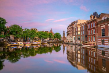 Amsterdam şehir merkezi silüeti. Gün batımında Hollanda 'da şehir manzarası