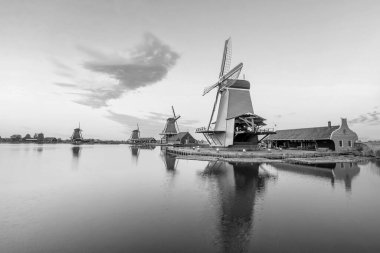 Traditional old village with dutch windmills in Amsterdam, Netherlands at sunset clipart