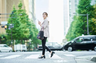  Genç bir kadın şehirde günlük kıyafetlerle dolaşıyor.