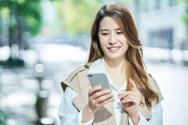 Jonge Vrouw Houdt Een Smartphone Buiten — Stockfoto