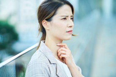 Asyalı genç kadın dışarıda kendini iyi hissetmiyor.