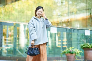  Şehirde rahat bir ifadeyle yürüyen bir kadın.