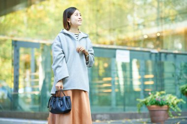  Şehirde rahat bir ifadeyle yürüyen bir kadın.