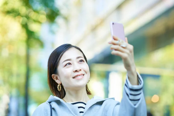Jovem Mulher Segurando Smartphone Livre — Fotografia de Stock
