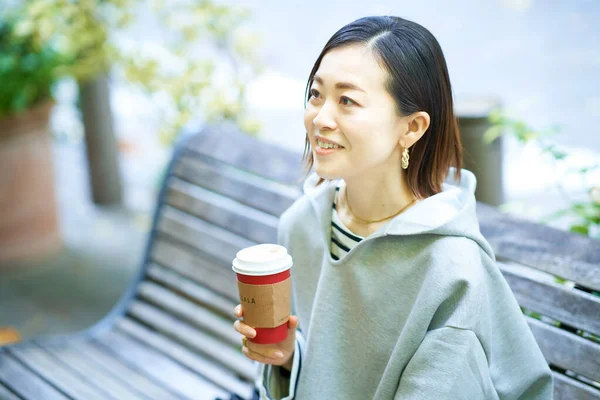 Vrouw Die Koffie Drinkt Met Een Ontspannen Uitdrukking Buiten — Stockfoto