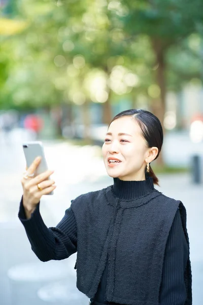 スマートフォンの画面を見るビジネス女性 — ストック写真