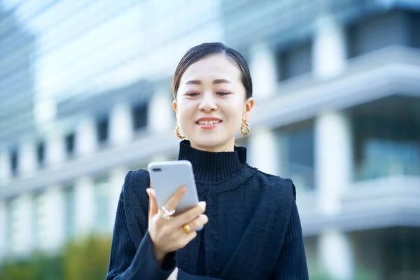 スマートフォンの画面を見るビジネス女性 — ストック写真