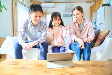 Ebeveynler ve çocuklar mutlu bir şekilde tablet ekranına bakıyorlar.