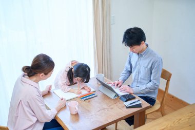 Anne ve kız oynuyor, resim yapıyor ve baba odada çalışıyor.