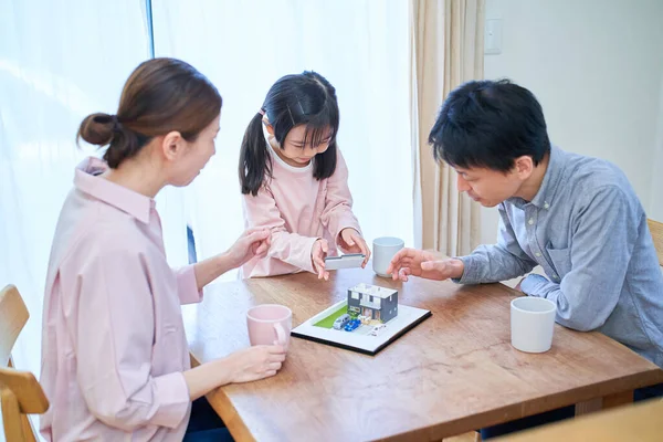 Eine Familie Diskutiert Beim Anblick Eines Modells Eines Einfamilienhauses — Stockfoto